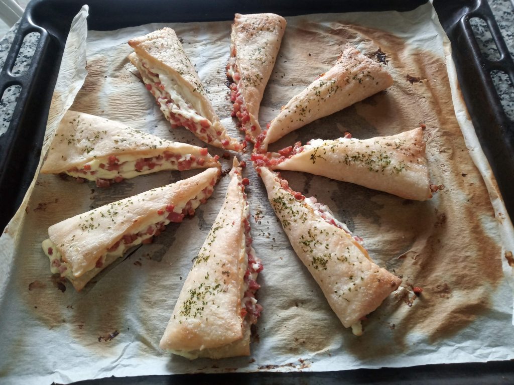 Triángulos de hojaldre con queso de untar y taquitos de jamón