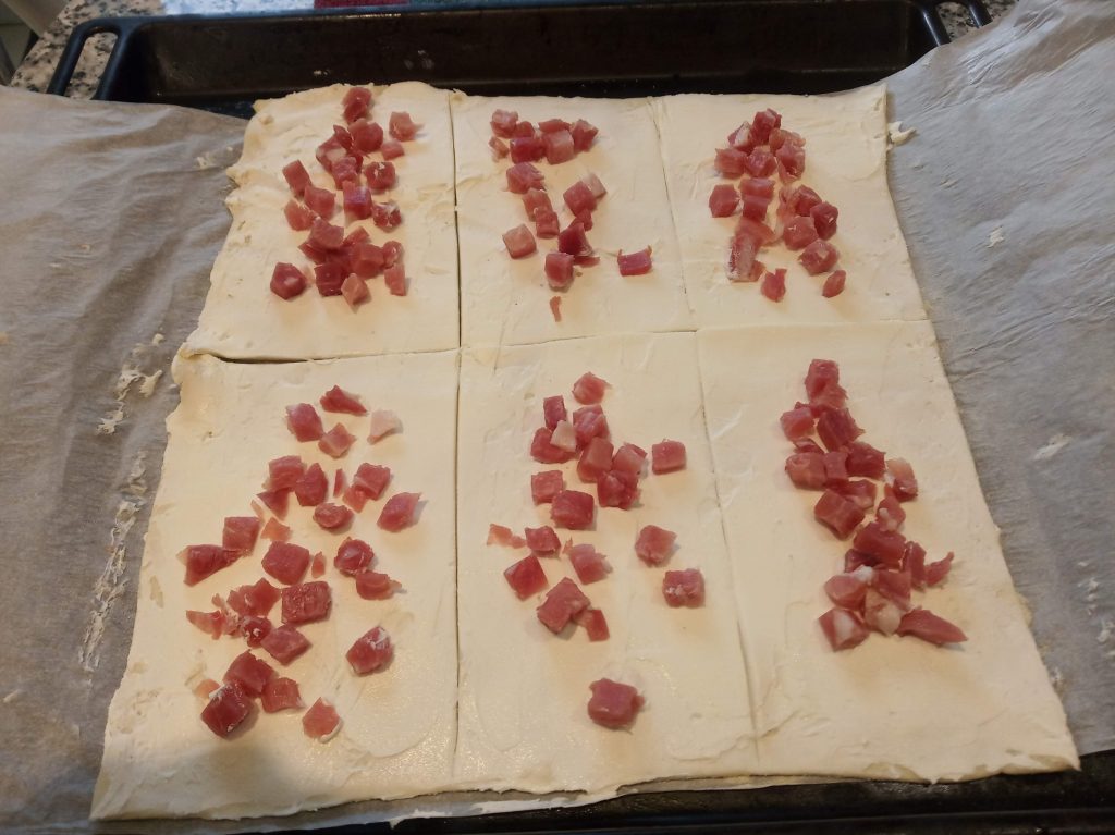 Triángulos de hojaldre con queso de untar y taquitos de jamón