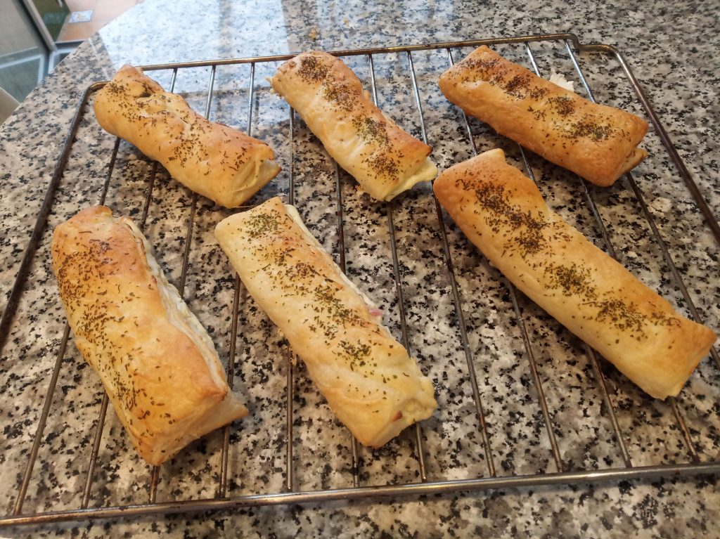 Triángulos de hojaldre con queso de untar y taquitos de jamón